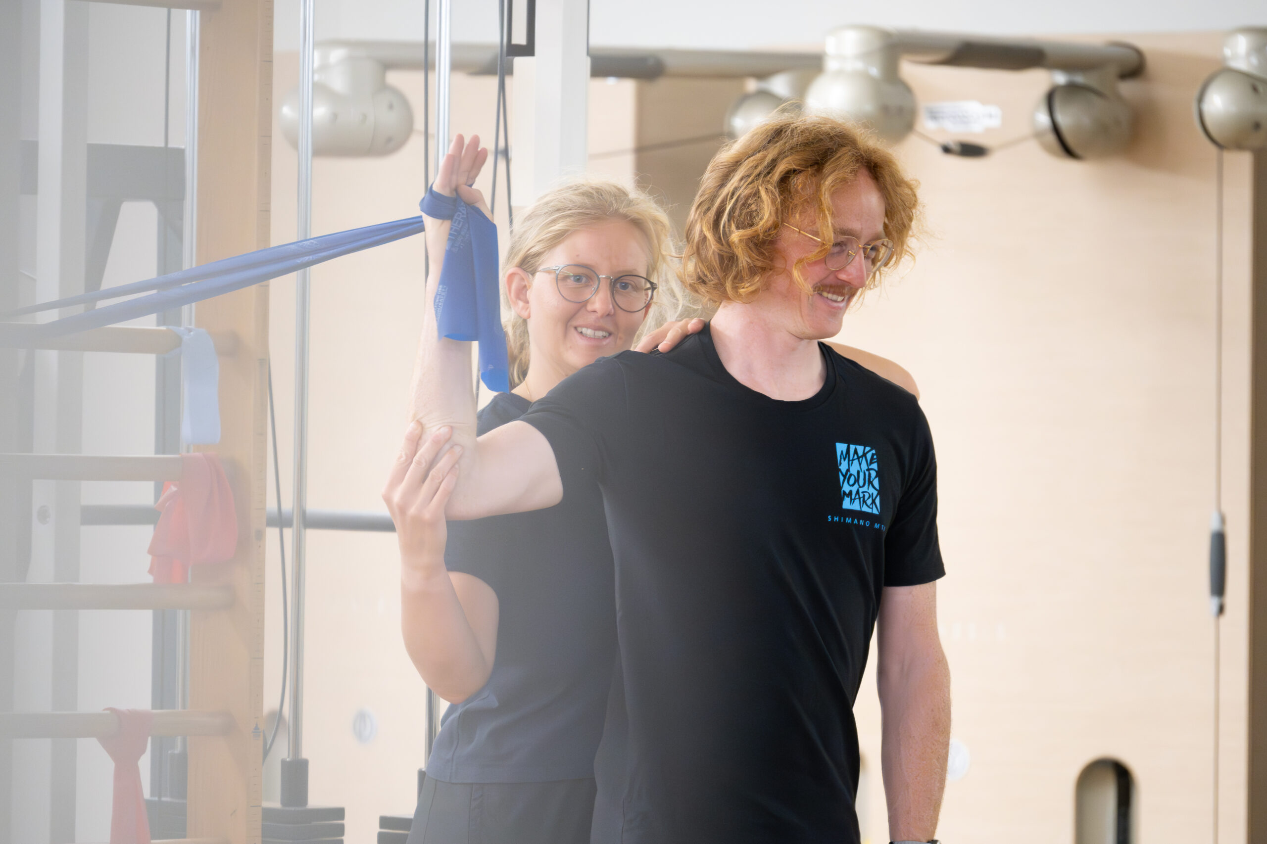 Schulterbeweglichkeitsübung mit Theraband in der Physiotherapie zu Hause in Basel